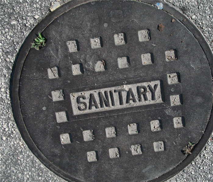 A sewer cover says "Sanitary"