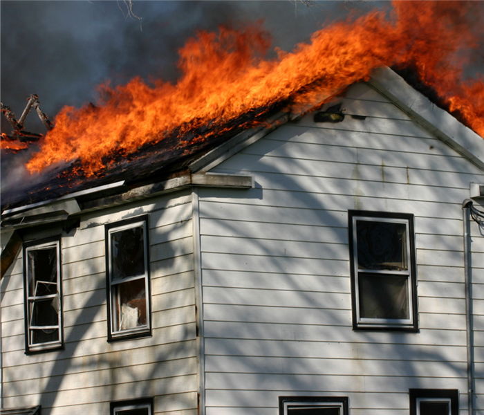 House on fire with flames on roof.