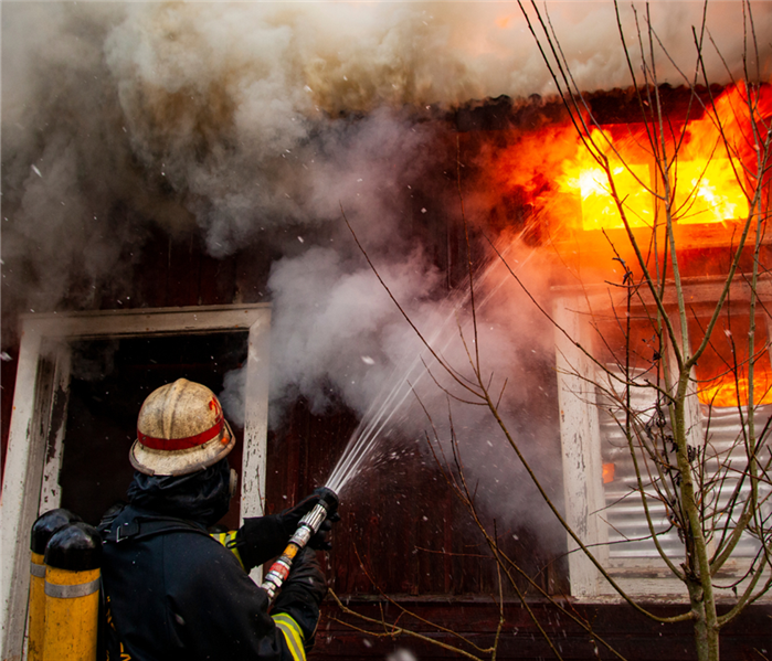 firefighter putting out house fire