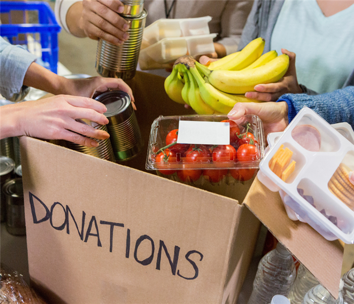 Picture shows a cardboard box filled with donations. 