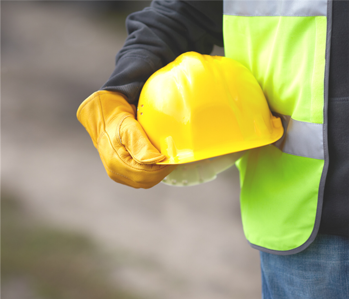 person holding a yellow hard hat